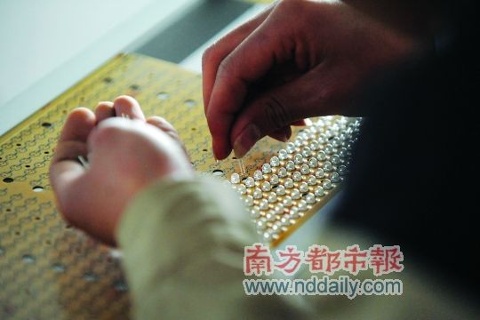 工人忙著安裝用于燈具發(fā)光的LED燈珠，這類工作處于LED燈具生產(chǎn)的最下游。資料圖